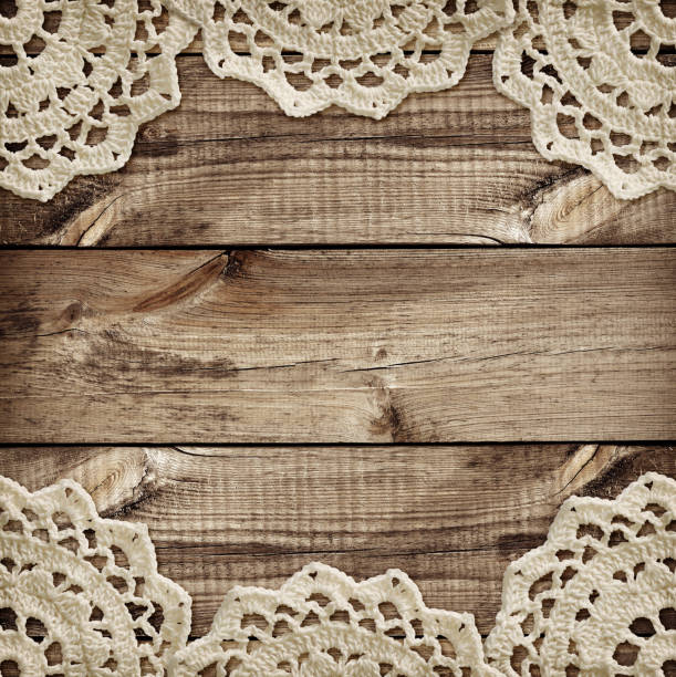 istock Brown wooden board and small crochet doilies in borders 910793344