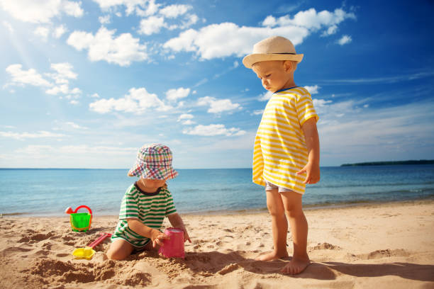 istock Boy and girl playing on the beach 910794630
