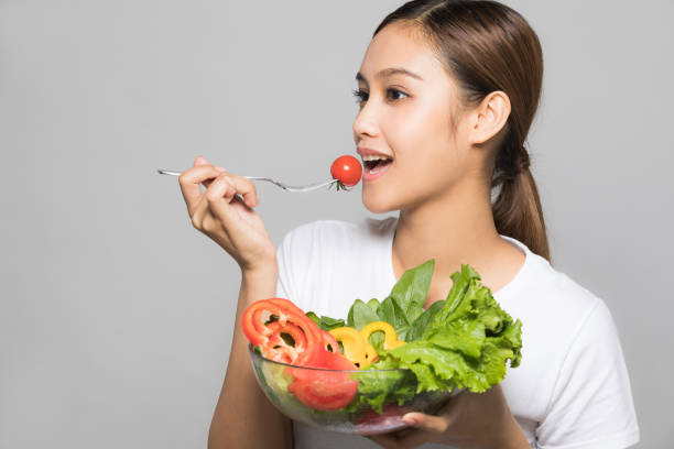 istock Young woman eating a salad. 910794774