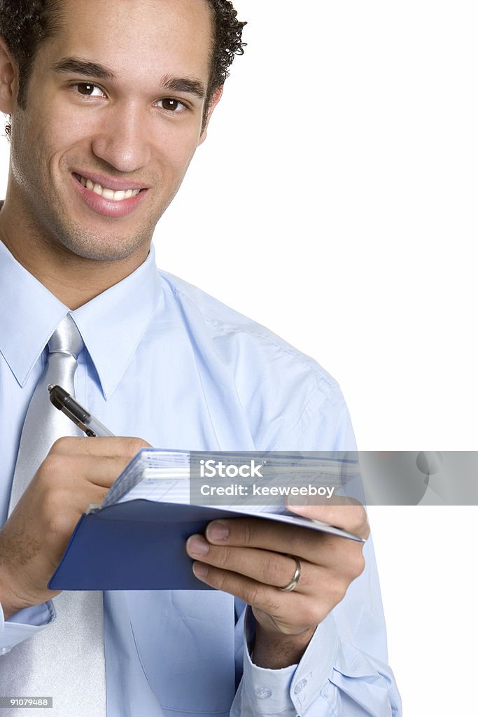 Smiling man writing out a check against white background Businessman writing checks Adolescence Stock Photo