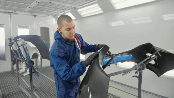 istock Serviceman preparing a car bodykit for painting in a workshop 910798892