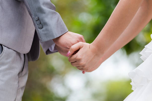 istock Bride and groom holding hands in wedding celemony 910809924