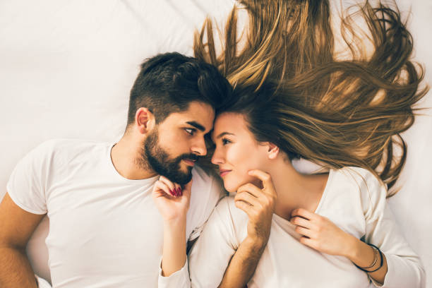 istock Romantic couple lying together on bed 910810332