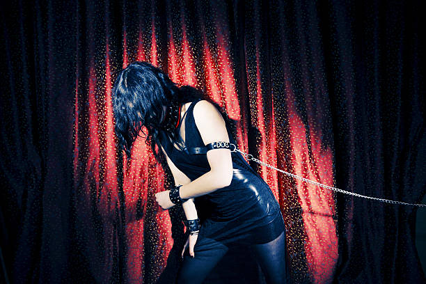 Goth Young Goth girl, chained to the wall. Tied Up Bondage Women Fetish Wear stock pictures, royalty-free photos & images