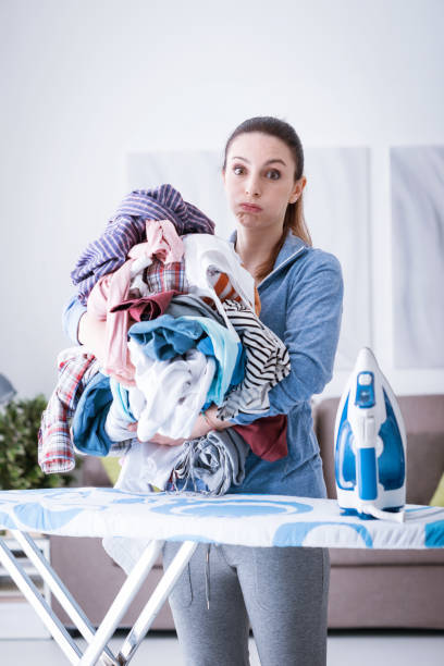 boring household chores - iron women ironing board stereotypical housewife imagens e fotografias de stock