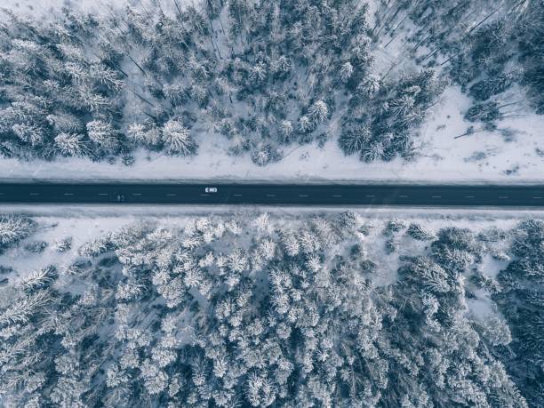 landsvägen går igenom den vackra snön täckte landskap. flygfoto. - vinter väg bil bildbanksfoton och bilder