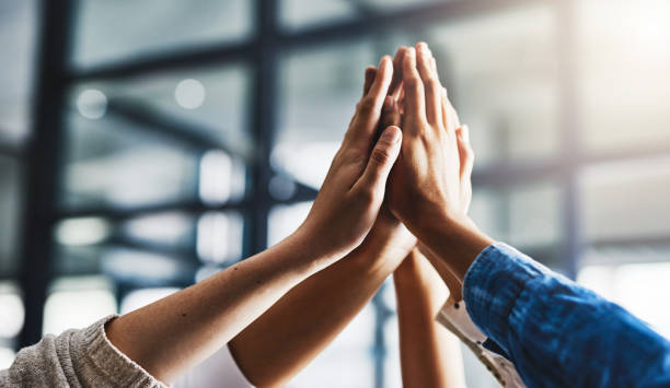 Unity packs in some powerful outcomes Closeup shot of a group of unrecognizable people high fiving together Unity stock pictures, royalty-free photos & images