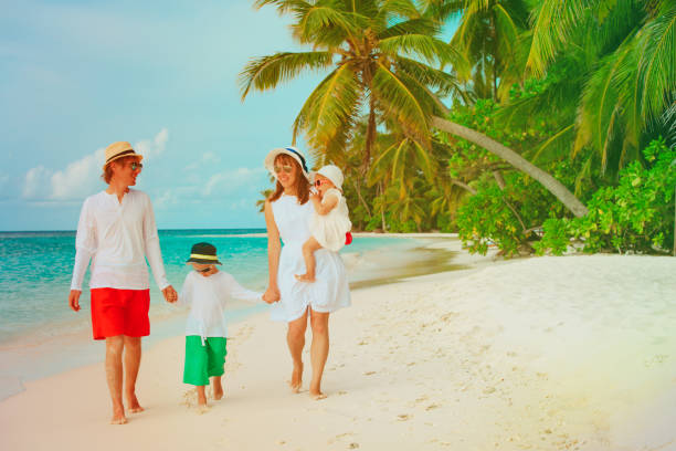 istock happy family with two kids walking on beach 910840538