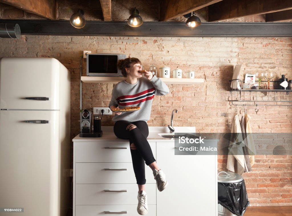 Schönes Mädchen essen Pizza in einer modernen Küche - Lizenzfrei Küche Stock-Foto