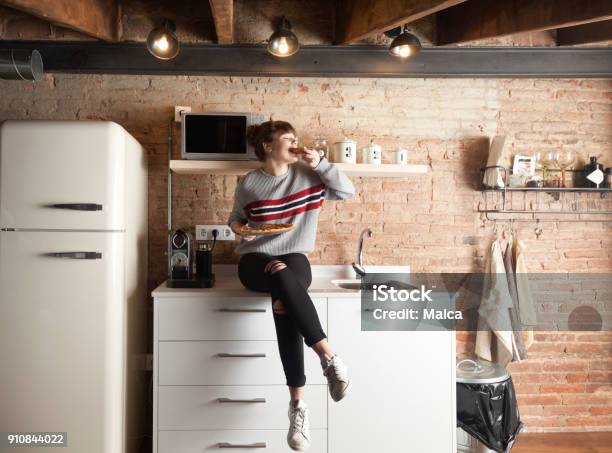 Schönes Mädchen Essen Pizza In Einer Modernen Küche Stockfoto und mehr Bilder von Küche