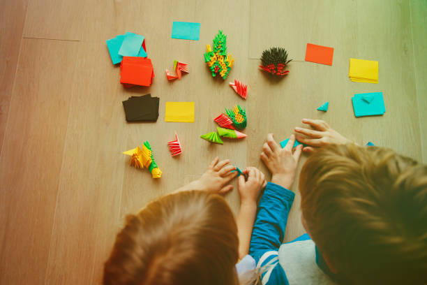 istock kids making origami crafts with paper 910844396