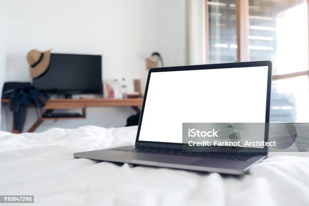 Mockup Image Of Laptop With Blank White Desktop Screen On The Bed In Bedroom Stock Photo - Download Image Now