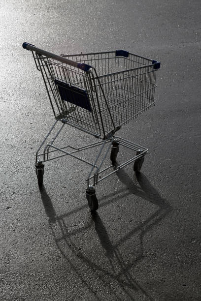 istock metal trolley for purchases on wet asphalt 910852282
