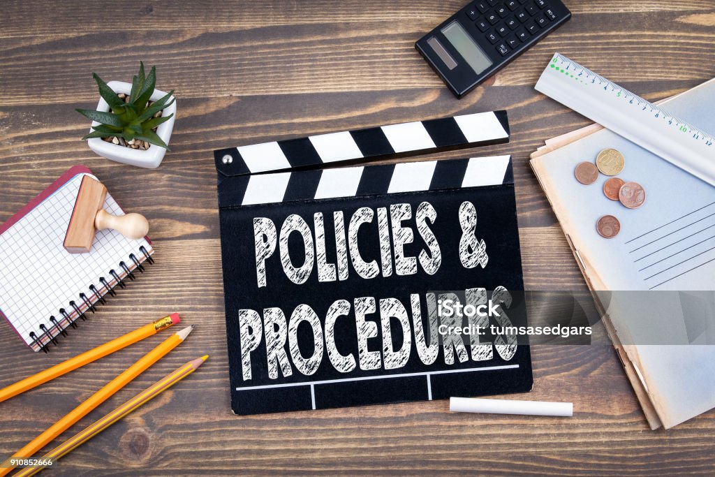 Policies and Procedures. movie clapper on a wooden desk Instructions Stock Photo