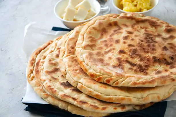 Mashed potato and sheep cheese filling flatbread on a white stone background.