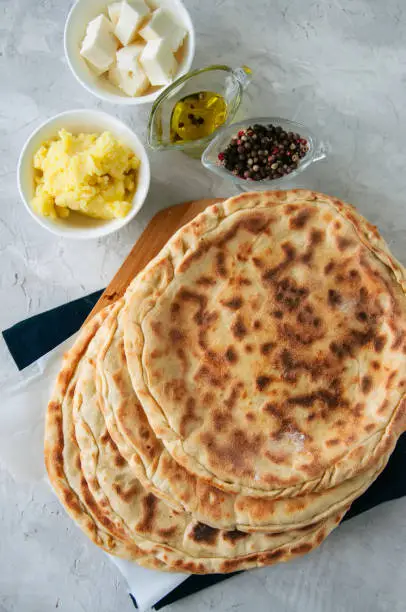 Mashed potato and sheep cheese filling flatbread on a white stone background.