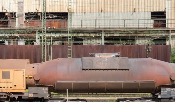 weathered rusty industrial scenery with old corroded torpedo car filled with molten pig iron