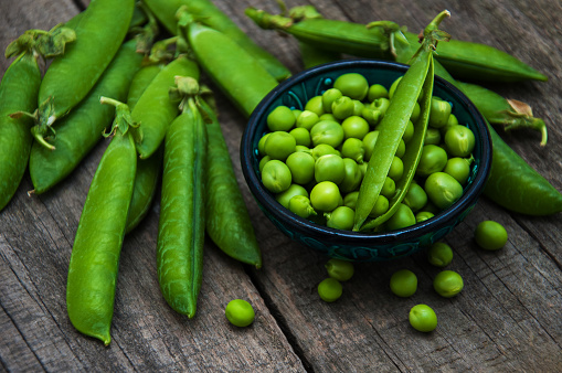 green peas  on rustic white wooden background