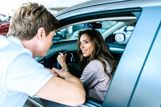 istock man talking to woman sitting in car 910856196