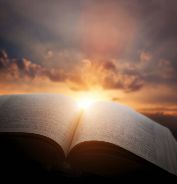 開いている古い本は、夕焼け空、天からの光。教育、宗教概念 - 聖書 ストックフォトと画像