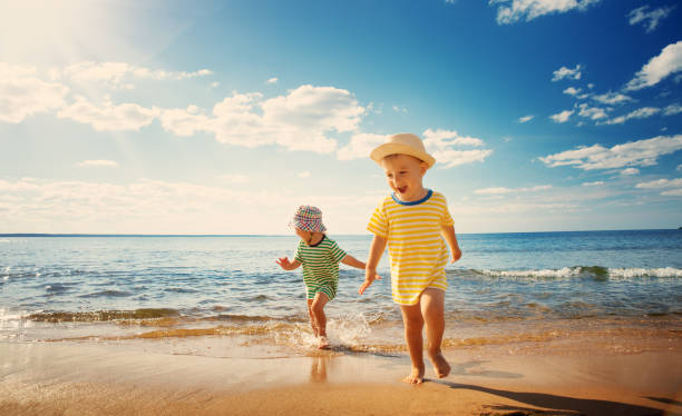 남자아이 및 여자아이 게임하기 해변 - summer beach multi colored vacations 뉴스 사진 이미지
