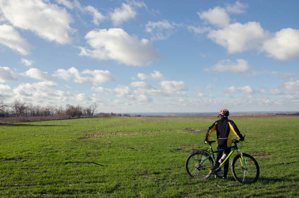 istock man with a bicycle on a green field 910862566