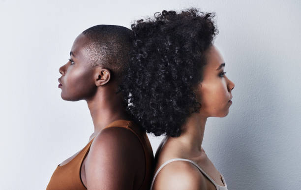 No one is you and that’s why you’re beautiful Studio shot of two beautiful young women standing back to back against each other against a gray background shaved black women stock pictures, royalty-free photos & images