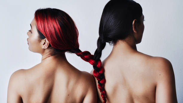 Strong as individuals and even stronger together Rearview studio shot of two beautiful young women tied together by their hair against a gray background black hair braiding stock pictures, royalty-free photos & images