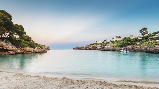 Sun sets over beautiful remote beach with white sand. Cala d’or, Mallorca.