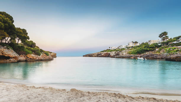 Majorca Beach Sunset Sun sets over beautiful remote beach with white sand. Cala d’or, Mallorca. coastal feature stock pictures, royalty-free photos & images