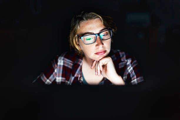 jovem mulher pensativa em sua tela de computador - teenager dark pensive emotional stress - fotografias e filmes do acervo