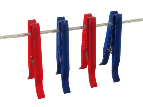 Blue and red clothespins on a clothes line, isolated on white. Contains clipping path.
