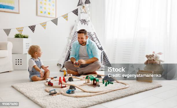 Feliz Padre Y Niño Hijo De Familia Jugando En Ferrocarril Del Juguete En La Sala De Juegos Foto de stock y más banco de imágenes de Niño