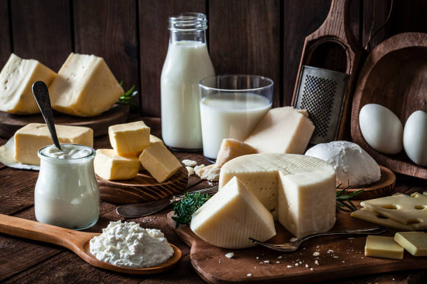 молочные продукты, снятые на деревенском деревянном столе - сыр стоковые фото и изображения