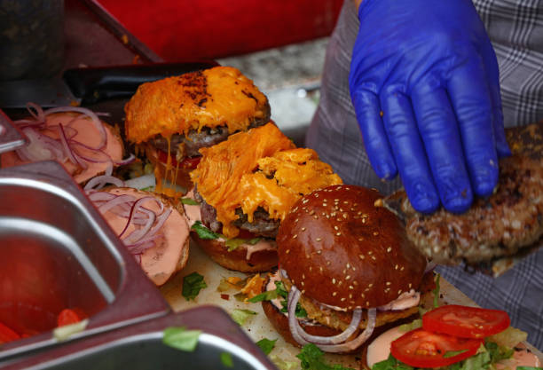 istock Close-Up Of Cropped Hand Making Burger On Table 910892200