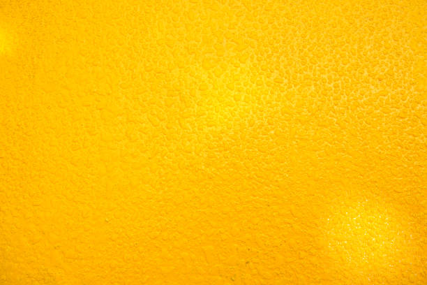 istock Full Frame Shot Of Water Drops On Yellow Table 910894452