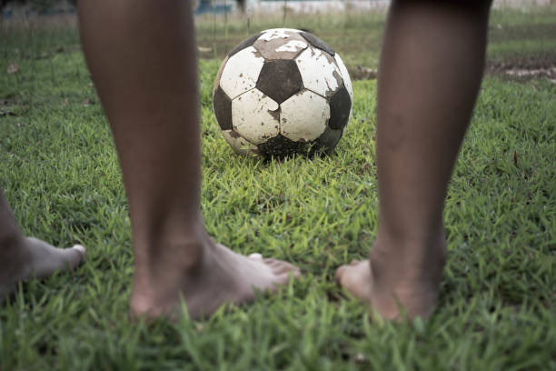 istock Low Section Of Boys Playing Soccer On Field 910894906
