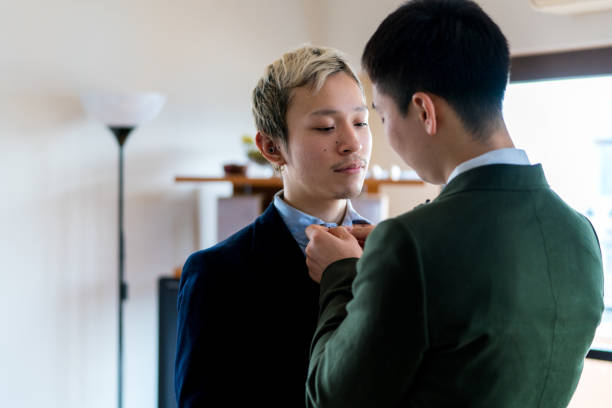 istock Young male couple helping each other to get ready 910906238