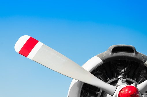 Vintage airplane propeller with radial engine on blue sky background