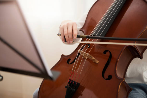 istock music student girl playing cello at home 910915550