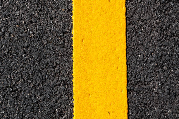 istock Yellow line on new asphalt detail 910924838