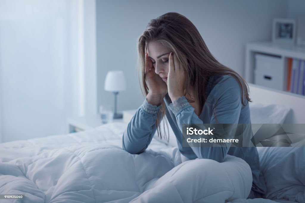 Depressed woman awake in the night Depressed woman awake in the night, she is exhausted and suffering from insomnia Insomnia Stock Photo