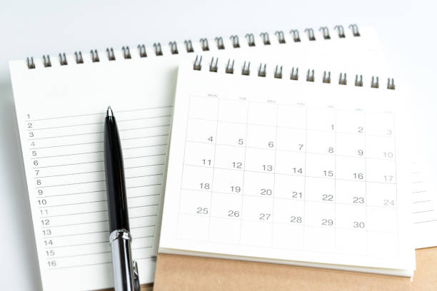 istock Personal yearly to do lists or new year's resolution or plan concept by clean calendar and  list of numbers on white notepad with pen 910926220