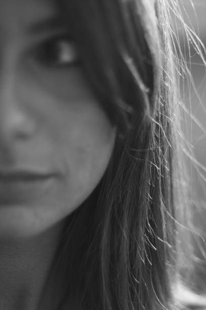 istock Young woman black and white portrait. Half face, blurred, focus on background. 910926918