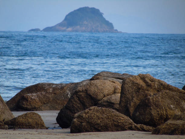 Beach with stones, sea and island in background