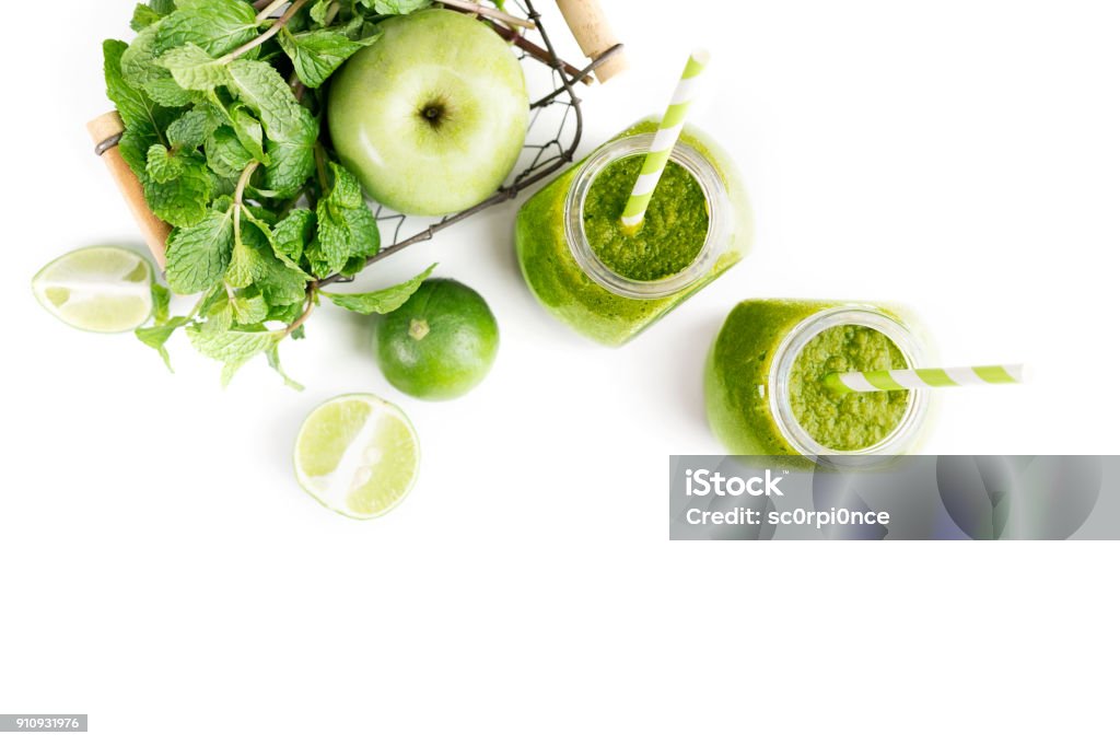 Green healty drink in two mason jars with green apple, mint and lime on white background. Vegetarian food concept. Detox Green healty drink in two mason jars with green apple, mint and lime on white background. Vegetarian food concept. Detox. Text space Smoothie Stock Photo