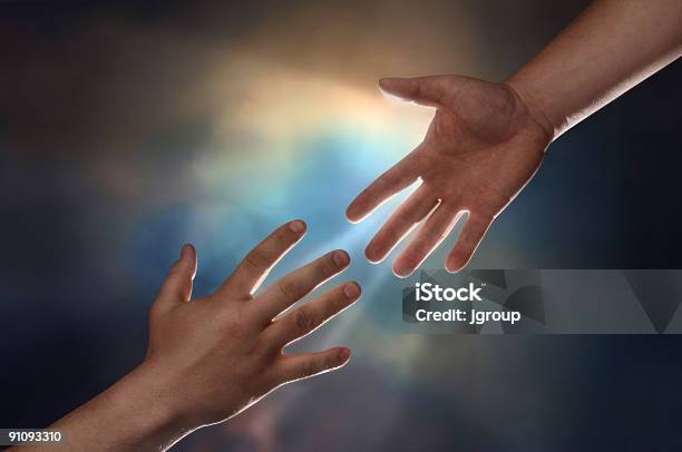 Two Hands Reaching For Each Other With A Bright Light Stock Photo - Download Image Now