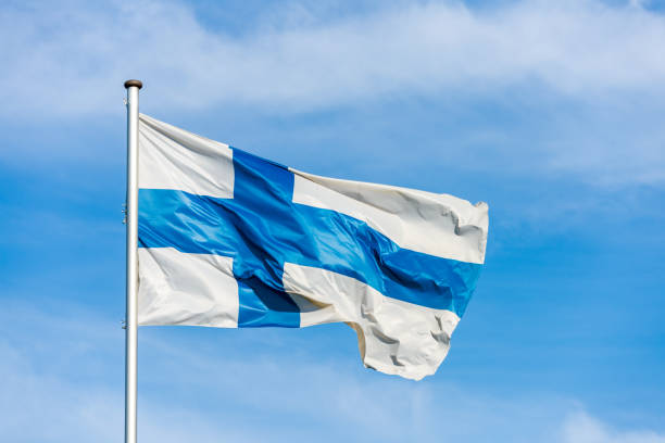 istock Finnish flag waggling in the wind with sky in background 910934542