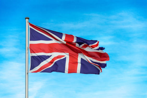 istock British union jack flag waggling in the wind with sky 910938696
