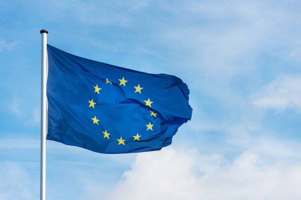 istock European flag waggling in the wind with blue sky 910940284